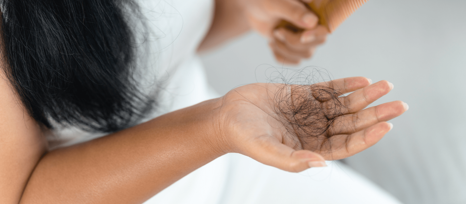 woman holding hair that fell out while brushing it
